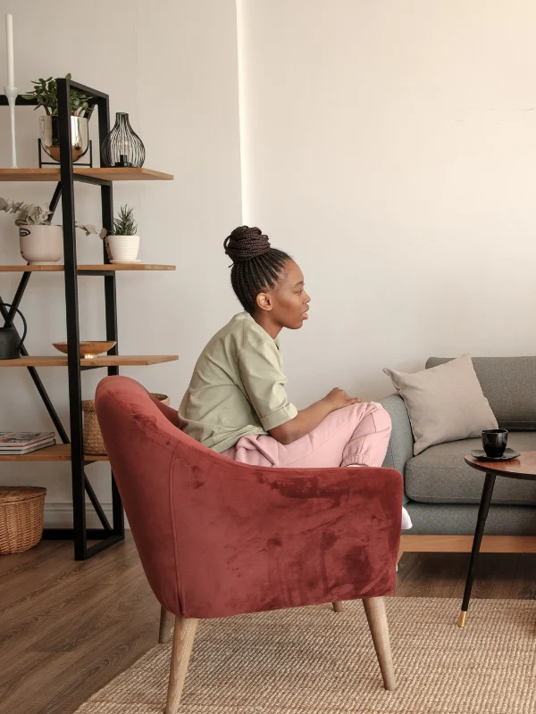 A young woman sits on an armchair and listens to her therapist during Acceptance and Commitment Therapy in Calgary at Be Well Psychology. Cognitive Behavioral Therapy