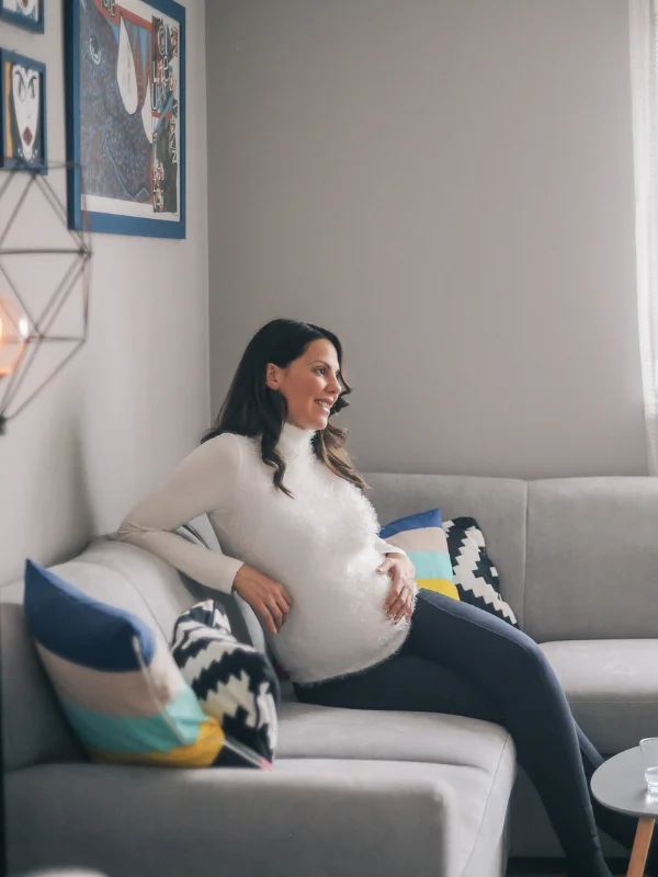 A pregnant woman sits on a couch for Accelerated Resolution Therapy in Calgary for trauma, anxiety & PTSD.